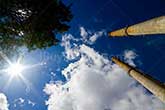 factory chimneys with sun and clouds in the sky